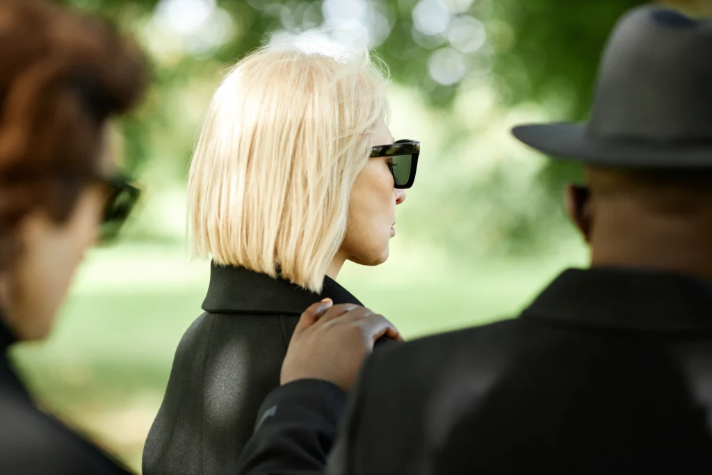 woman wearing dark sunglasses at funeral 2026 01 08 06 41 09 utc
